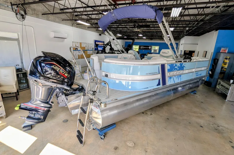 Slide: The Image of 2026 Trifecta CS 22RF pontoon boat in showroom, featuring outboard motor and blue accents. - 5
