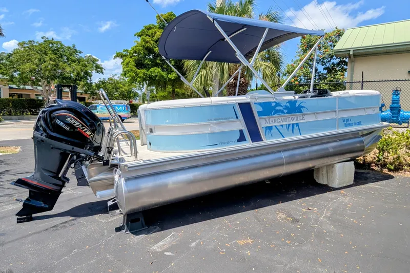 Slide: The Image of 2026 Trifecta CS 22RF pontoon boat with Yamaha motor, parked outdoors under blue sky. - 7