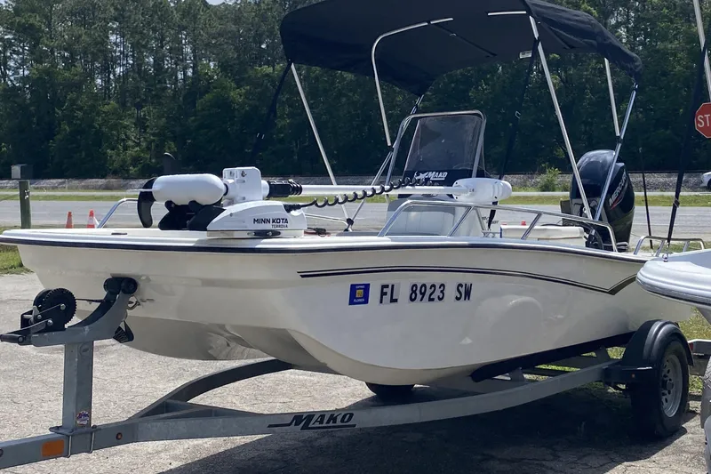 The Image of 2021 Mako Pro Skiff 15 CC boat on trailer with canopy and motor. - 1