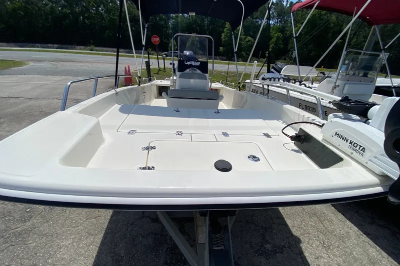 Slide: The Image of 2021 Mako Pro Skiff 15 CC boat with Minn Kota motor, parked outdoors. - 10