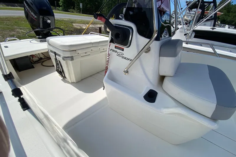Slide: The Image of 2021 Mako Pro Skiff 15 CC interior with seating and storage, featuring a Mercury engine. - 12