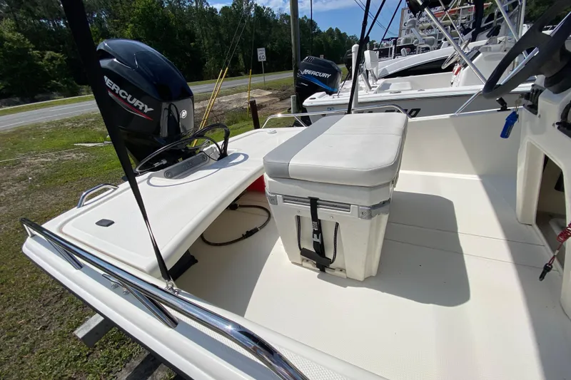 Slide: The Image of 2021 Mako Pro Skiff 15 CC boat interior with Mercury engine, featuring seating and storage. - 13