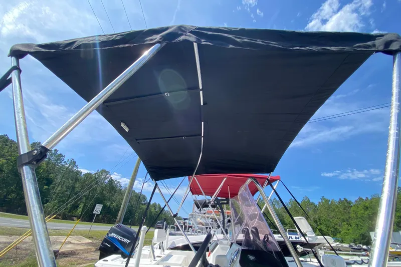 Slide: The Image of 2021 Mako Pro Skiff 15 CC with canopy under blue sky. - 14