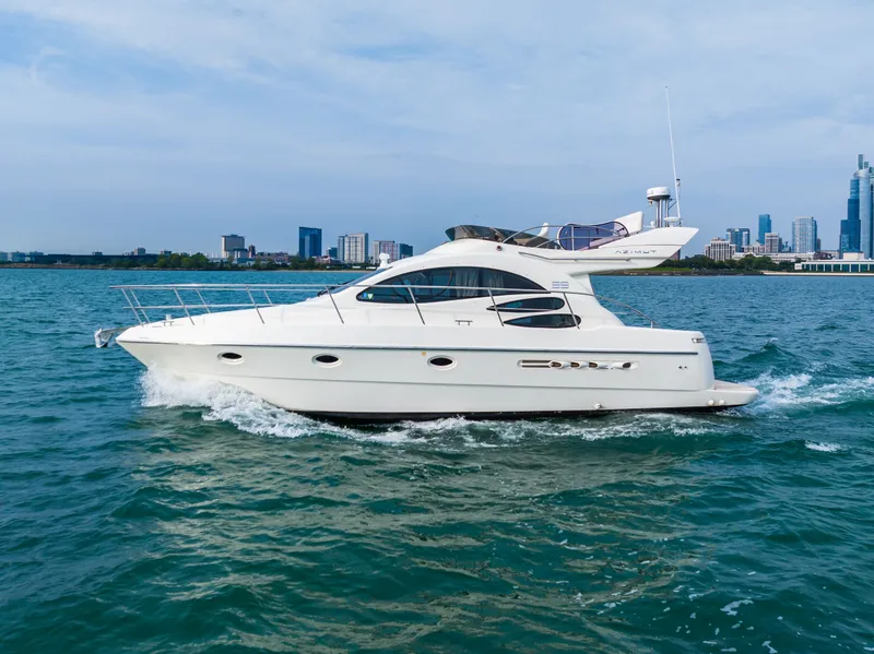 Slide: The Image of 2004 Azimut 39 Flybridge yacht cruising on water near city skyline. - 18