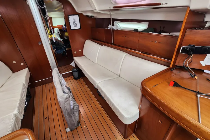 Slide: The Image of Interior of 2004 Beneteau First 36.7 sailboat with wooden flooring and white seating. - 11