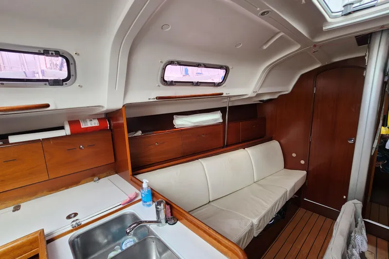 Slide: The Image of Interior of 2004 Beneteau First 36.7 sailboat with wooden cabinetry and white seating. - 15