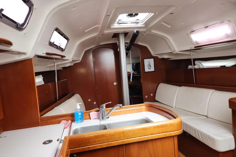 Slide: The Image of Interior of 2004 Beneteau First 36.7 sailboat with wood finish and white seating. - 20