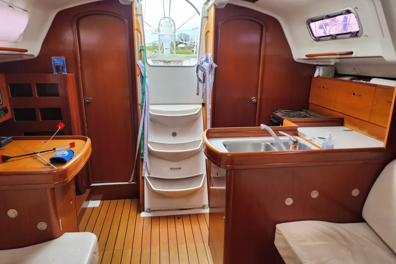Slide: The Image of Interior of a 2004 Beneteau First 36.7 sailboat with wood finish and compact kitchen. - 21