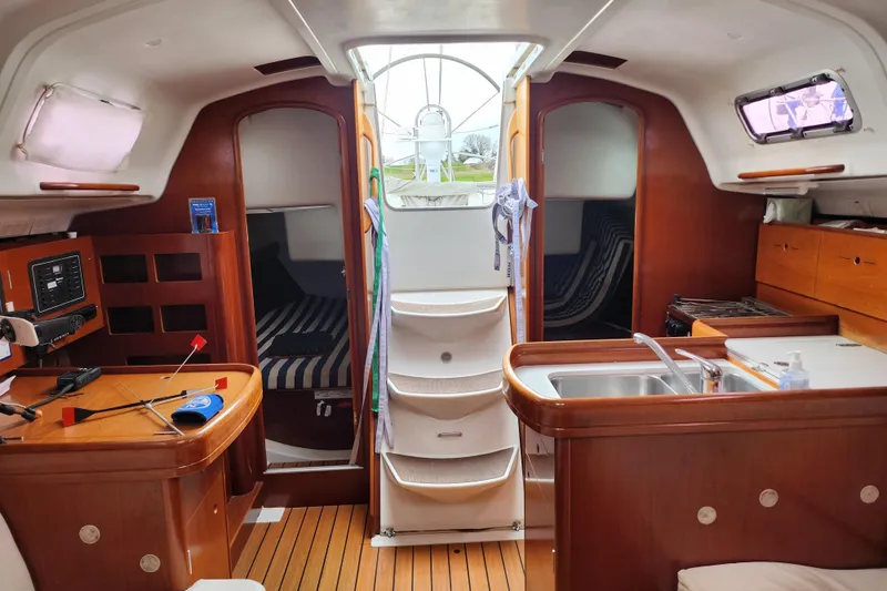 Slide: The Image of Interior of 2004 Beneteau First 36.7 sailboat with wood finish and compact kitchen. - 22