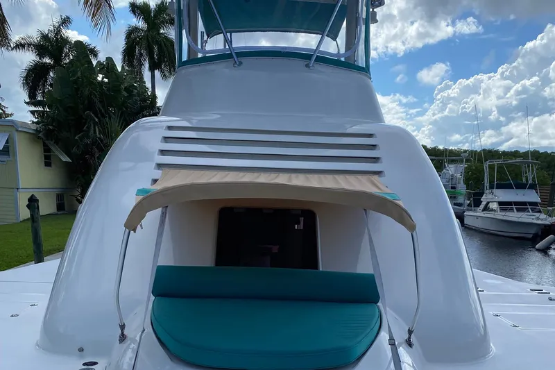 Slide: The Image of Custom 64 Stuart Catamarans 2002 with shaded seating, docked near palm trees and other boats. - 10