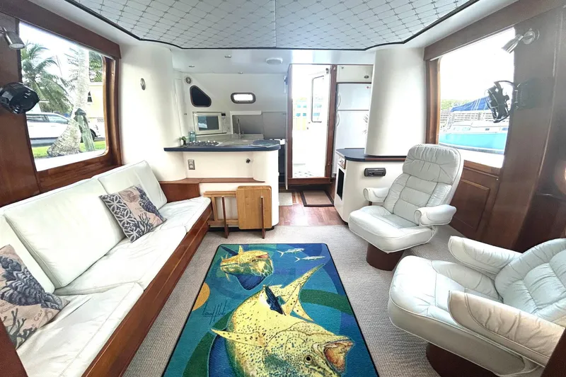 Slide: The Image of Luxurious 2002 Custom 64 Stuart Catamarans interior with plush seating and vibrant fish-themed rug. - 21