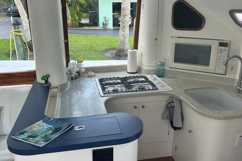 Slide: The Image of Modern kitchen interior on a 2002 Custom 64 Stuart Catamaran with stove, sink, and microwave. - 29