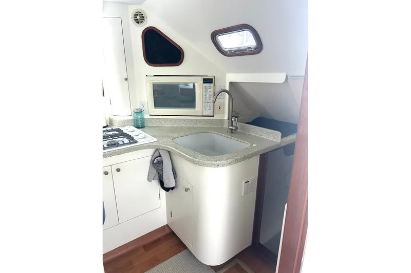 Slide: The Image of Compact kitchen area in 2002 Custom 64 Stuart Catamarans with sink, stove, and microwave. - 30
