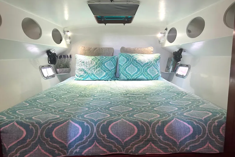 Slide: The Image of Cozy bedroom in 2002 Custom 64 Stuart Catamarans with patterned bedding and porthole windows. - 35