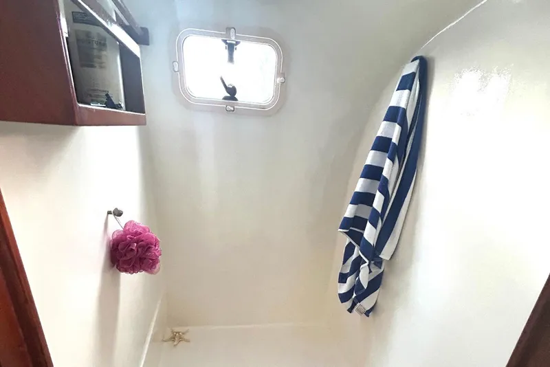 Slide: The Image of Bathroom interior of 2002 Custom 64 Stuart Catamarans with striped towel and porthole window. - 37