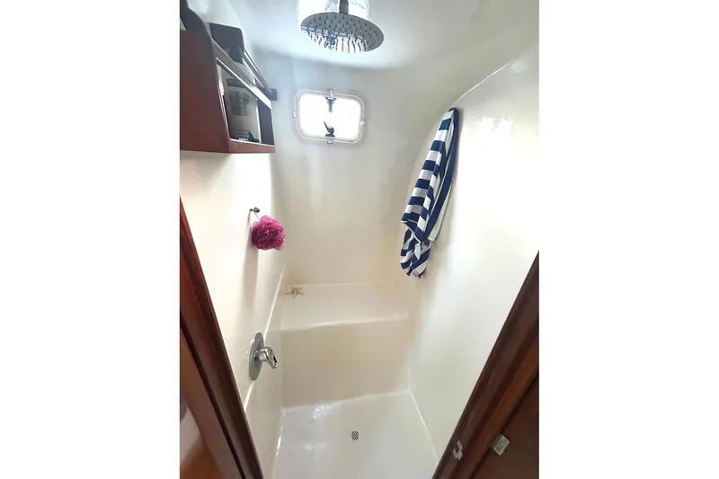 Slide: The Image of Shower area in 2002 Custom 64 Stuart Catamarans, featuring a window and striped towel. - 40