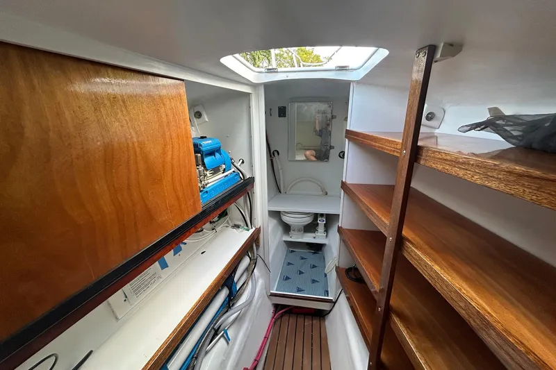 Slide: The Image of Interior of 2002 Custom 64 Stuart Catamarans with wooden shelves and compact bathroom. - 41