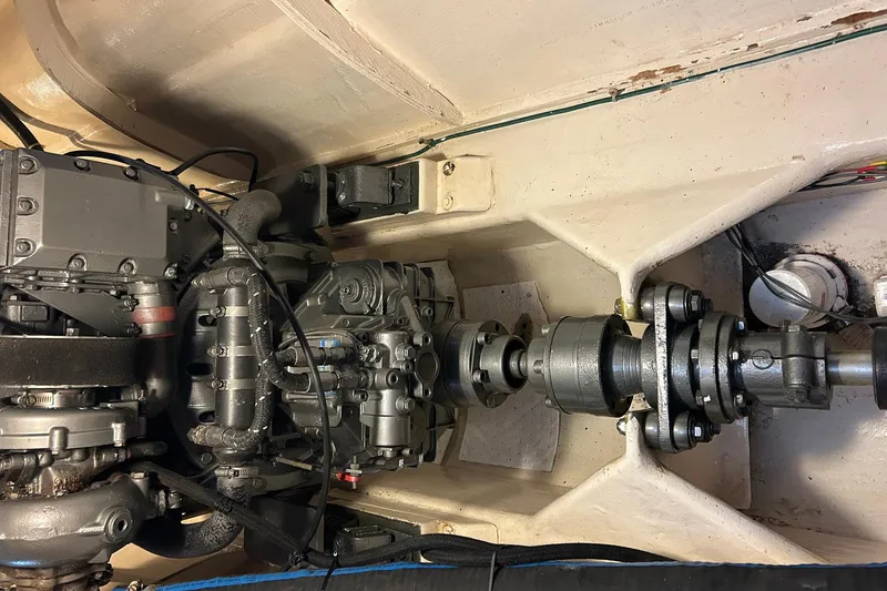 Slide: The Image of Engine compartment of a 2002 Custom 64 Stuart Catamarans, showcasing mechanical components and drive shaft. - 47