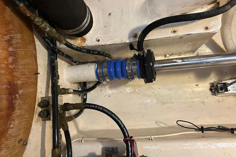 Slide: The Image of Engine compartment of 2002 Custom 64 Stuart Catamarans, showing mechanical components and hoses. - 48