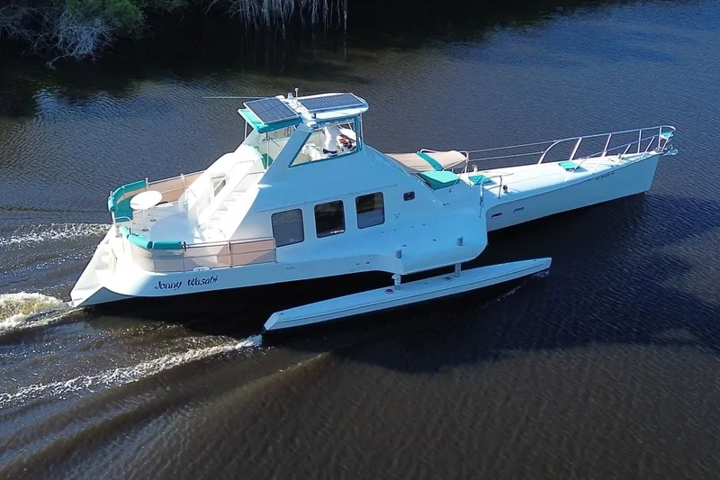 Slide: The Image of Custom 64 Stuart Catamarans 2002 sailing on calm waters, featuring sleek design and spacious deck. - 6