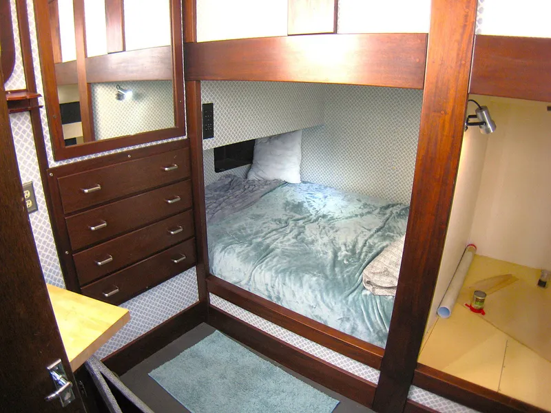Slide: The Image of Cozy cabin interior of 1987 Custom Pilgrim Tribute with bed, drawers, and wood accents. - 23