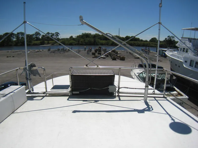 Slide: The Image of 1987 Custom Pilgrim Tribute boat on dry dock, with clear sky and waterfront view. - 38