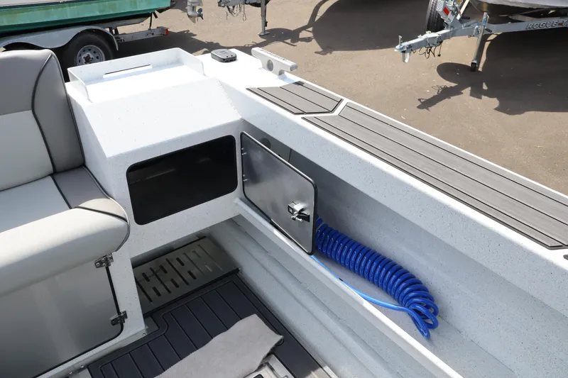 Slide: The Image of Interior of 2026 KingFisher 25 XAC boat with storage compartment and coiled blue hose. - 13