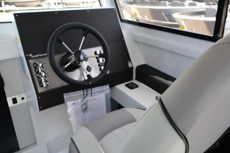 Slide: The Image of Interior of 2026 KingFisher 25 XAC boat showing steering wheel and control panel. - 21