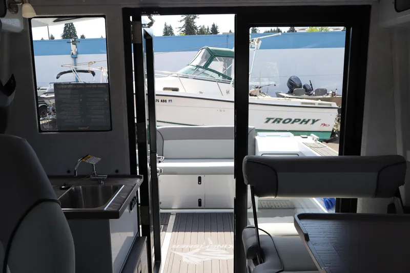 Slide: The Image of Interior view of 2026 KingFisher 25 XAC boat with outdoor marina scene. - 30
