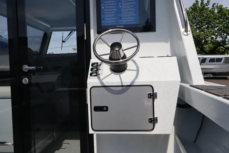 Slide: The Image of Steering console of 2026 KingFisher 25 XAC boat with modern controls and sleek design. - 6
