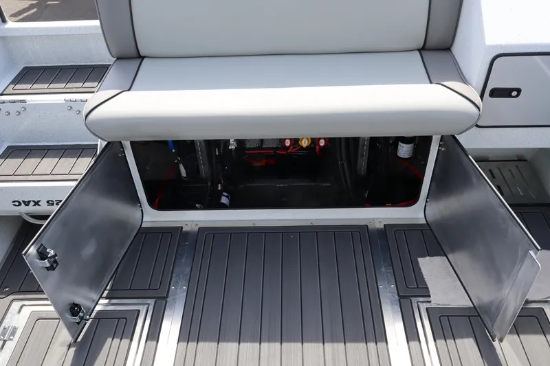 Slide: The Image of Open storage compartment on 2026 KingFisher 25 XAC boat with gray seating and flooring. - 8