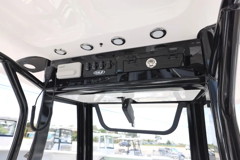 Slide: The Image of 2026 Sea Hunt Ultra 239 SE boat with T-top and rod holders under a clear blue sky. - 8