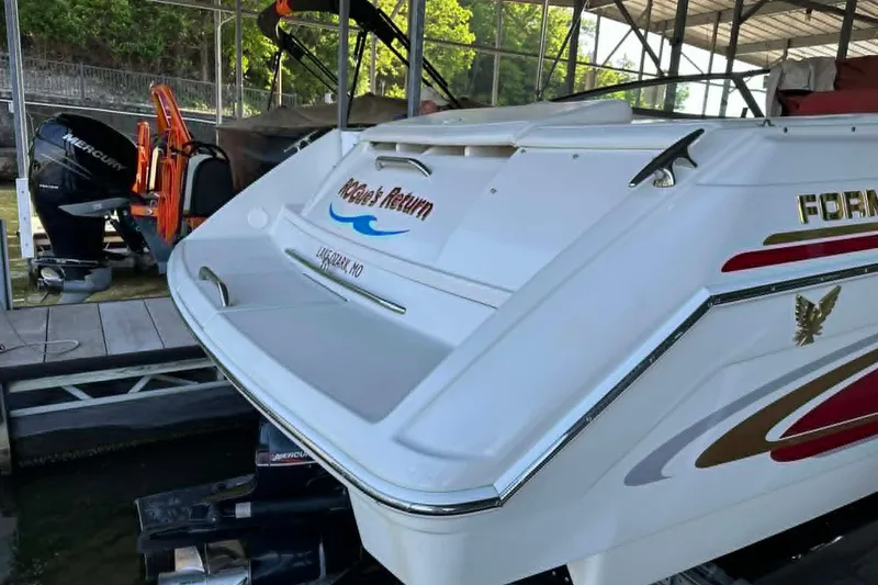 Slide: The Image of 2002 Formula 280 Bowrider boat docked, featuring sleek design and vibrant decals. - 13