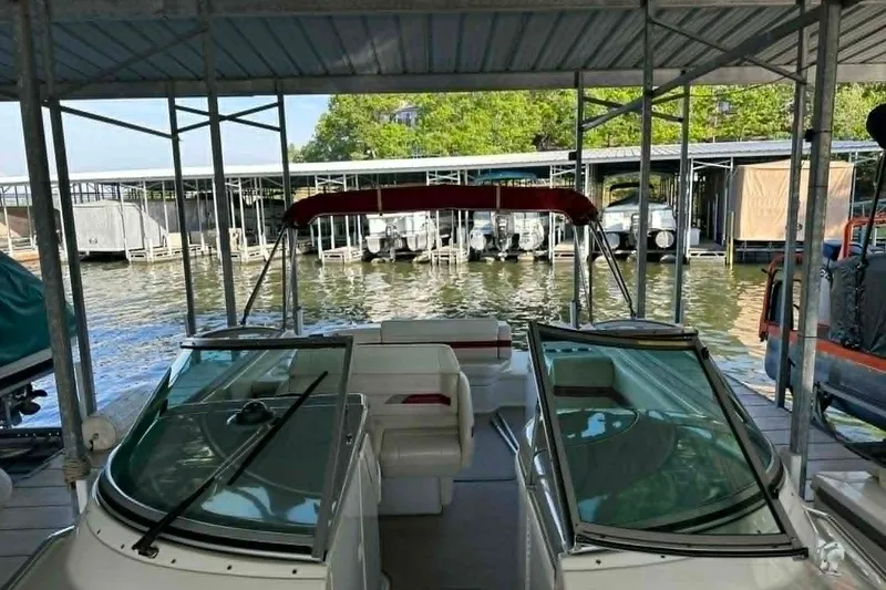 Slide: The Image of 2002 Formula 280 Bowrider docked in a marina, featuring a red canopy and spacious seating. - 16