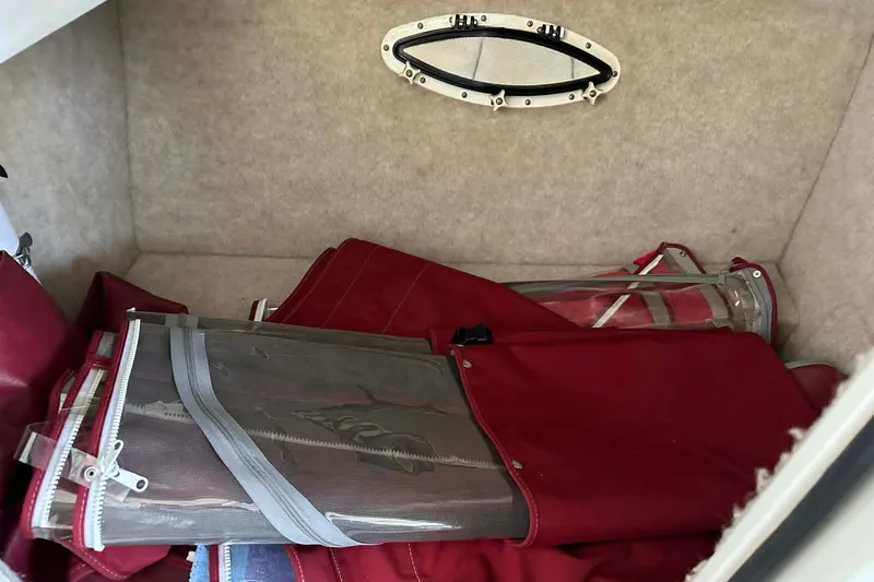 Slide: The Image of Storage compartment in a 2002 Formula 280 Bowrider boat with red canvas covers. - 22