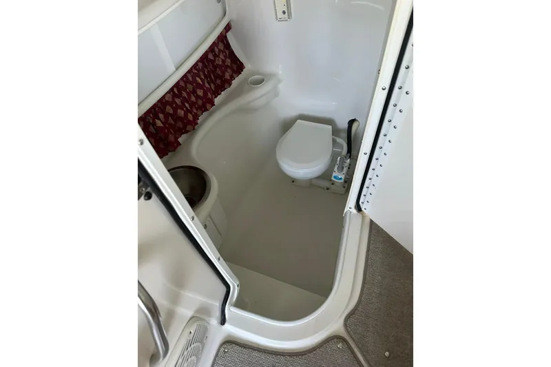 Slide: The Image of Compact bathroom in 2002 Formula 280 Bowrider boat, featuring a toilet and storage space. - 30