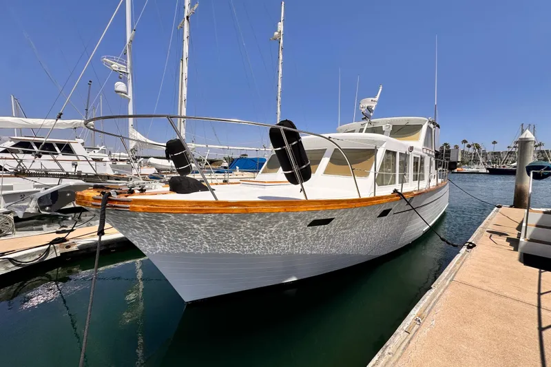 The Image of 1978 Roughwater 41 yacht docked at marina under clear blue sky. - 0