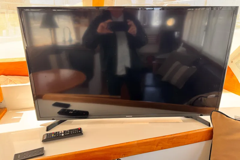 Slide: The Image of Samsung TV with remote on a 1978 Roughwater 41 boat interior. - 11