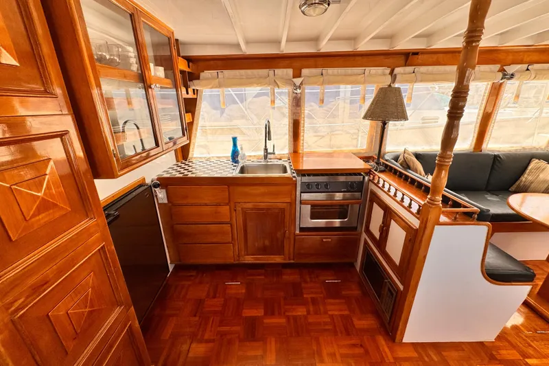Slide: The Image of 1978 Roughwater 41 boat interior with wooden cabinetry, kitchen, and seating area. - 13