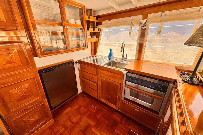 Slide: The Image of 1978 Roughwater 41 yacht kitchen with wooden cabinetry, stainless steel sink, and modern appliances. - 14