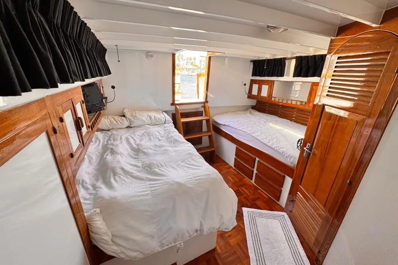 Slide: The Image of Cozy cabin interior of 1978 Roughwater 41 boat with wooden accents and twin beds. - 21