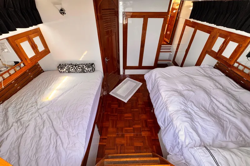 Slide: The Image of Interior of 1978 Roughwater 41 boat with twin beds and wooden accents. - 22
