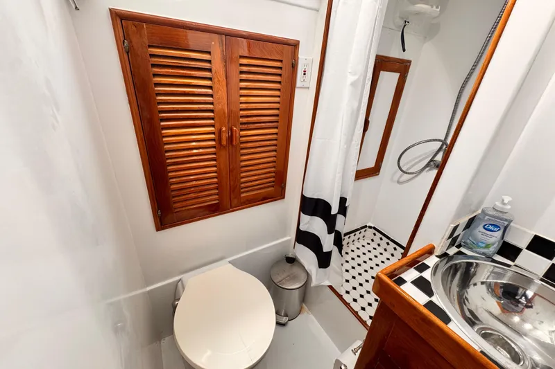 Slide: The Image of Bathroom interior of 1978 Roughwater 41 boat with wooden accents and modern fixtures. - 25