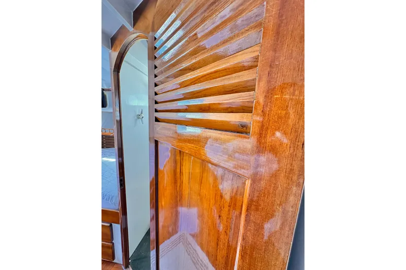 Slide: The Image of Polished wooden interior door of a 1978 Roughwater 41 boat cabin. - 28