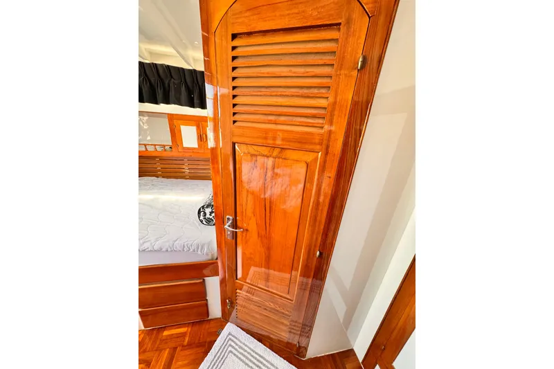 Slide: The Image of Wooden cabin interior of 1978 Roughwater 41 boat, featuring a polished door and cozy bed. - 29