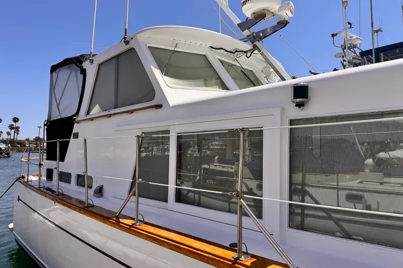 Slide: The Image of 1978 Roughwater 41 boat docked, featuring sleek design and spacious cabin windows. - 3