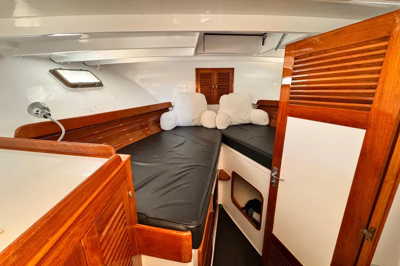 Slide: The Image of Cozy cabin interior of 1978 Roughwater 41 boat with wooden accents and plush bedding. - 30