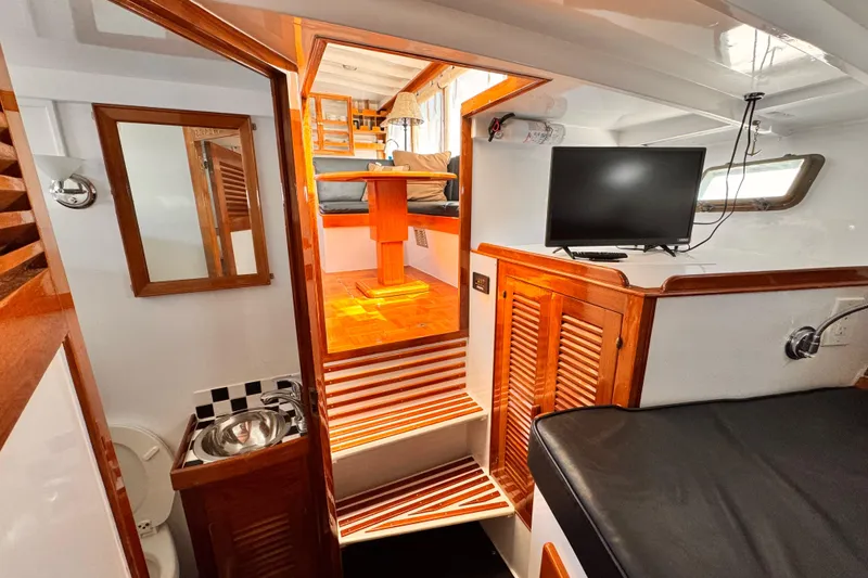 Slide: The Image of Interior of 1978 Roughwater 41 boat featuring wooden cabinetry, seating area, and mounted TV. - 33