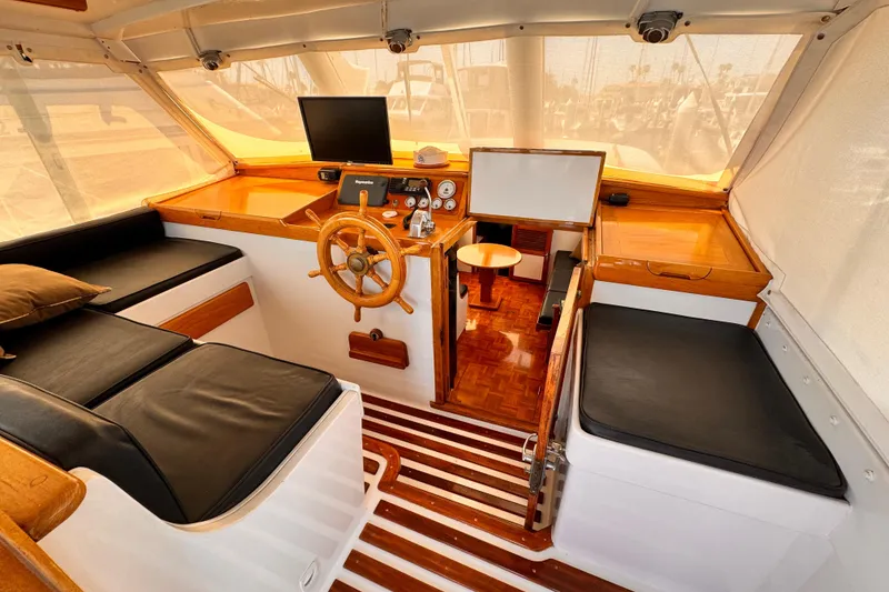 Slide: The Image of 1978 Roughwater 41 boat interior with wooden helm, black seating, and nautical instruments. - 39