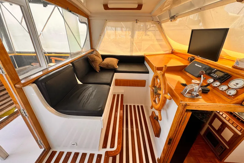 Slide: The Image of 1978 Roughwater 41 boat interior with wooden helm, black seating, and navigation equipment. - 40